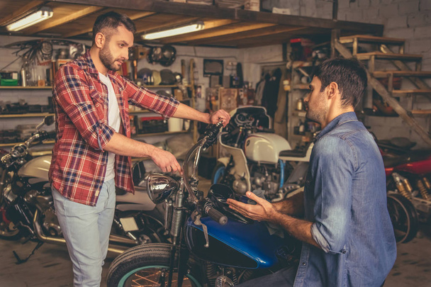 Les gars à l'atelier de réparation de motos
 - Photo, image