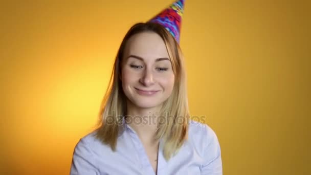 Beautiful girl blowing balloons on a yellow background - Materiaali, video