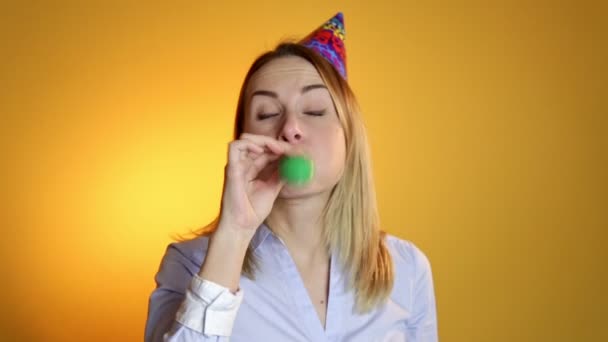 Girl inflating a balloon on a yellow background - Video