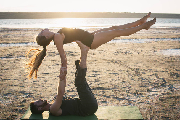 couple practicing acroyoga exercise - Фото, изображение