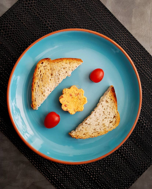 tostadas, tomates cherry y queso en plato azul, vista superior   - Foto, Imagen