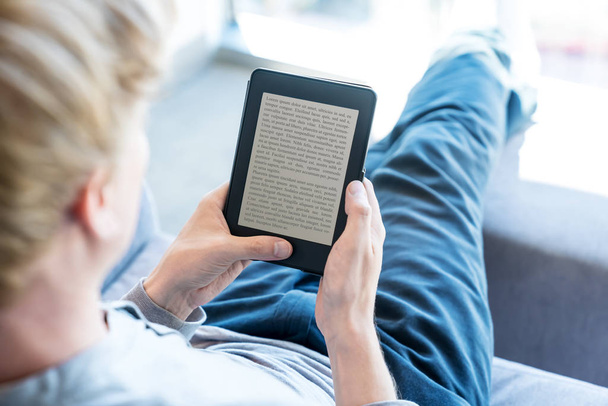 Man reading a book on digital device - Fotó, kép