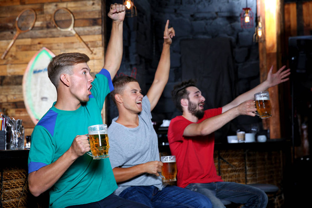 Cheerful friends with beer in sport bar - Foto, Imagem