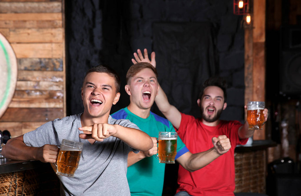 Cheerful friends with beer in sport bar - Фото, зображення