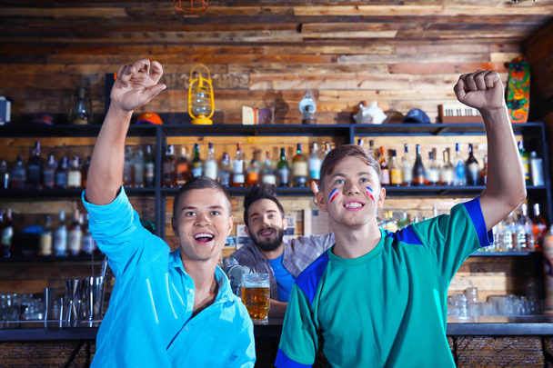 Cheerful friends with beer in sport bar - Photo, image