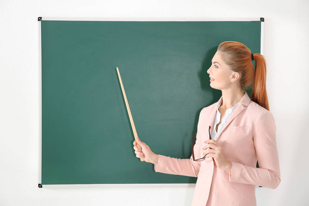 Blackboard yanında işaretçisiyle genç öğretmen   - Fotoğraf, Görsel