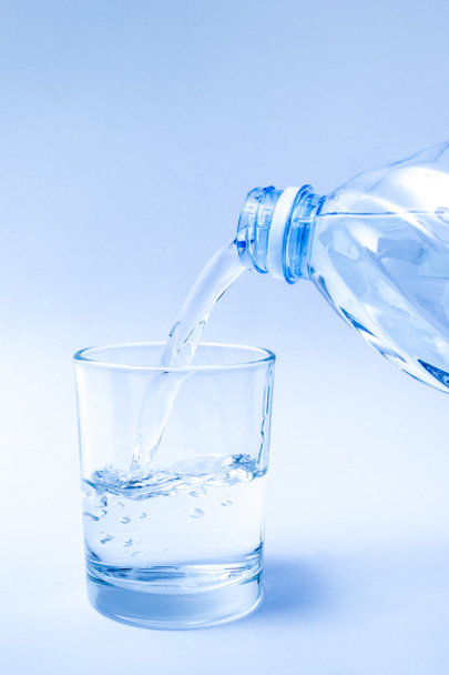 питьевая вода вылить в стакан синий тон цвета для чистой и свежей концепции
. - Фото, изображение