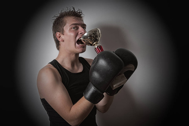 Boxer holding een kop in zijn handen - Foto, afbeelding