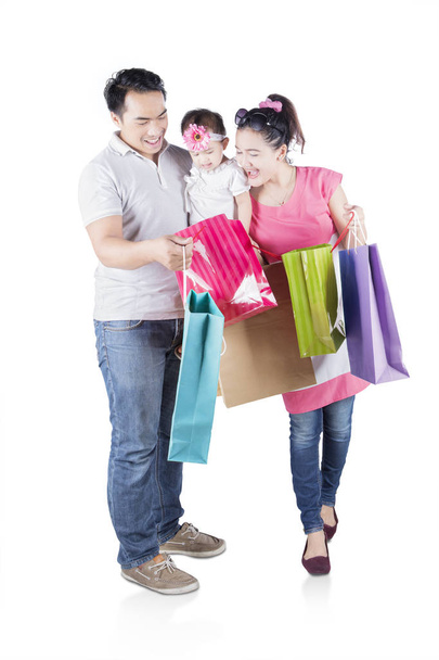 Cheerful family looking at shopping bag  - Foto, imagen