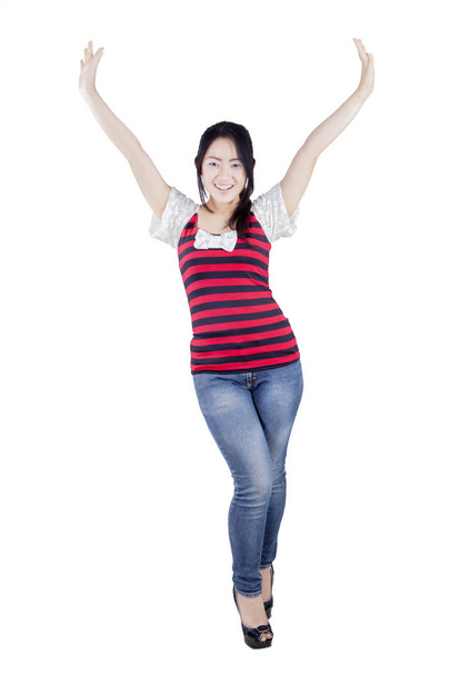 Cheerful woman raising hands on studio - Foto, afbeelding