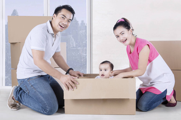 Happy parents and child play with box  - Valokuva, kuva