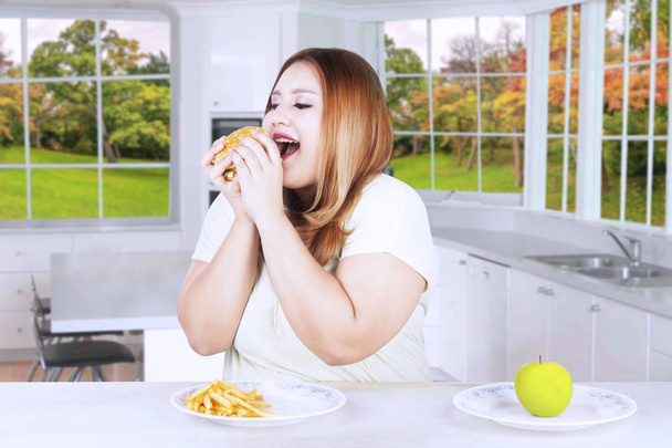 肥満女性のジャンク フードを食べることを選択 - 写真・画像