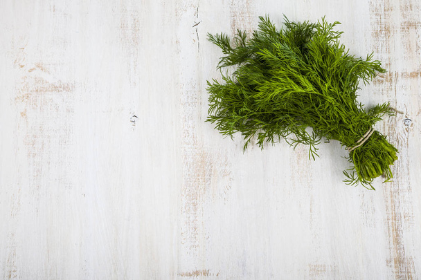 Fresh dill on a light wooden background - Foto, immagini