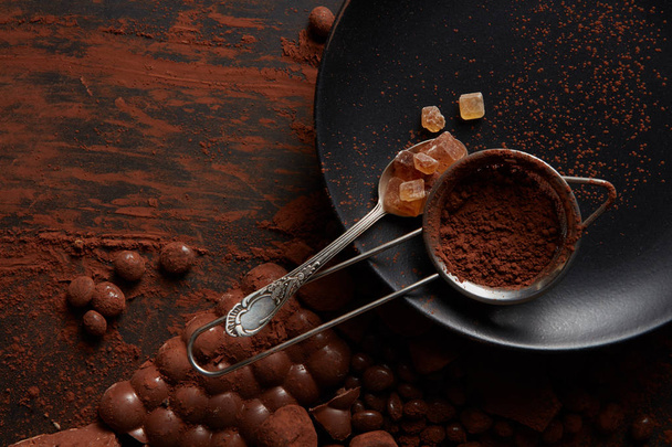 spoon with candies and cocoa powder - Foto, Imagen