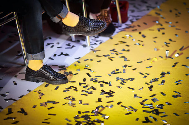 Mies jalat yllään vintage saappaat ja keltainen matto
 - Valokuva, kuva