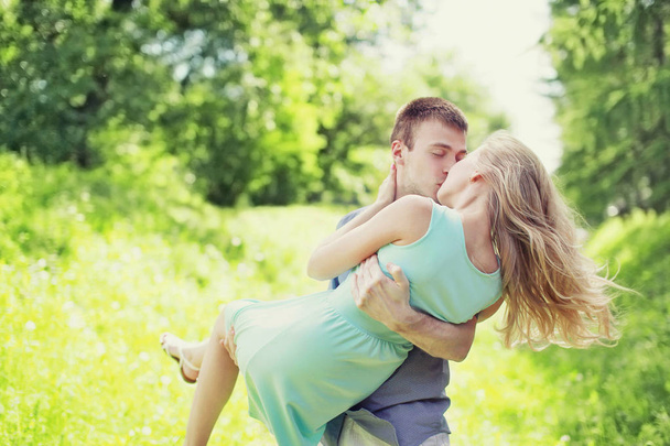 Sweet kiss young couple outdoors, man and woman in love, he hold - Фото, изображение