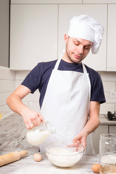 chef cook pours milk in a glass - Foto, Bild