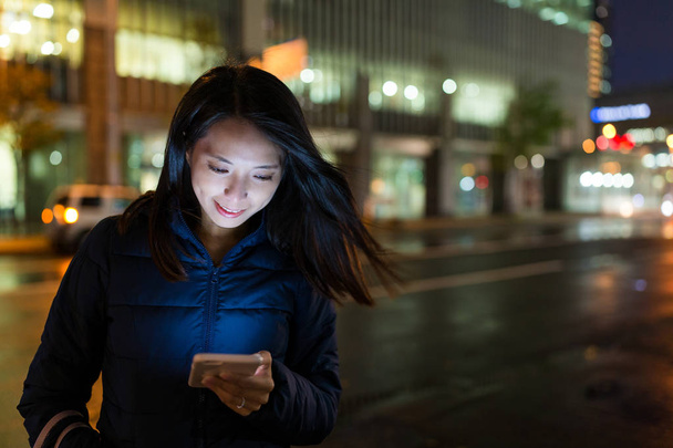 Woman using cellphone at night - Foto, imagen