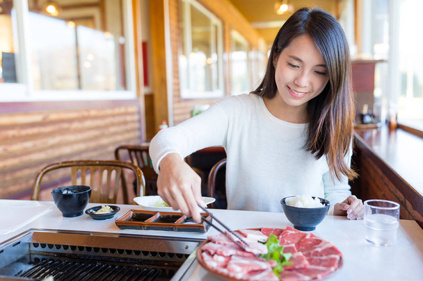 Woman grilled sliced of beef  - Photo, image