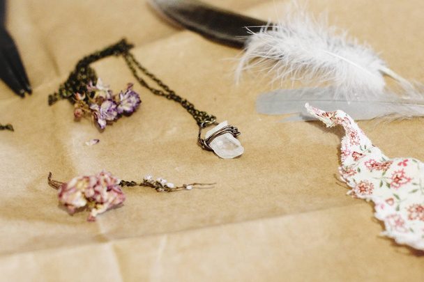 kristal kolye, tüy ve kuru çiçekler  - Fotoğraf, Görsel