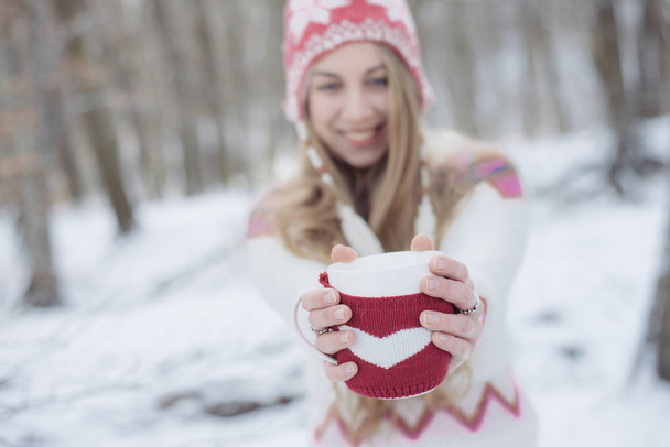 Hermosa chica tomando té o café al aire libre. Mujer con una taza de bebida caliente
. - Foto, Imagen