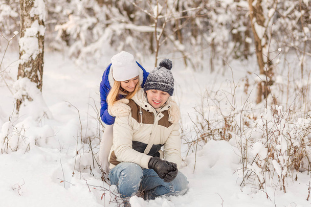 El muchacho y la muchacha descansan en el bosque invernal
.  - Foto, Imagen
