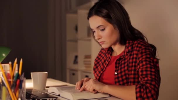 student girl or woman reading book at night home - Filmagem, Vídeo