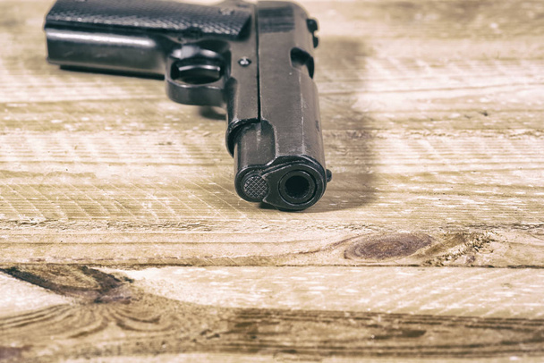solitary gun  on wooden background - Фото, зображення