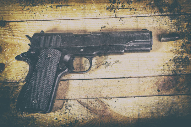 pistola solitaria sobre fondo de madera
 - Foto, imagen
