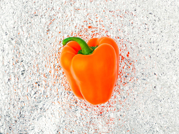 Raw orange pepper on foil. - Foto, Imagen