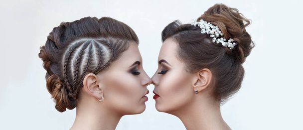 Kaksi kaunista nuorta naista, joilla on laadukas meikki, lähikuva kasvot kevyellä taustalla, jolla on ammattimainen kampaus
 - Valokuva, kuva