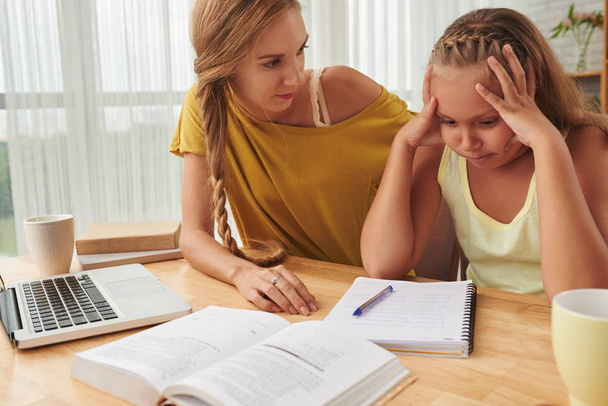 Mother helping daughter with homework - Фото, изображение