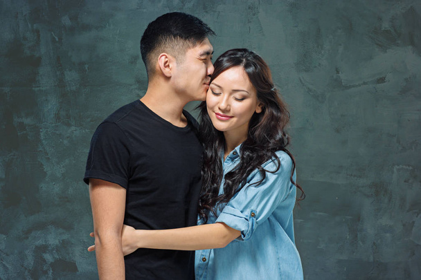 Portrait of smiling Korean couple on a gray - Foto, afbeelding