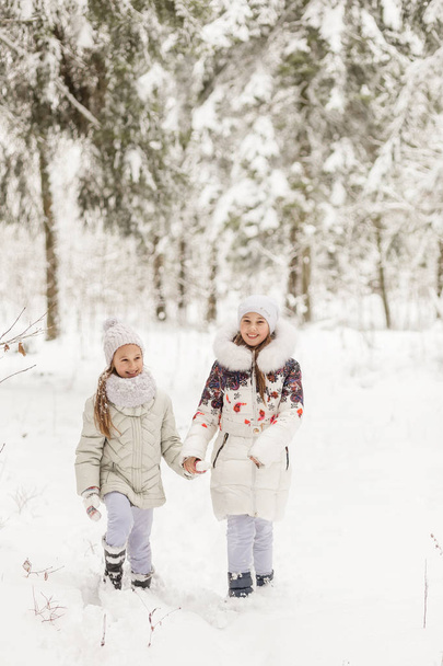 Two girlfriends playing in a winter forest.  - Photo, Image