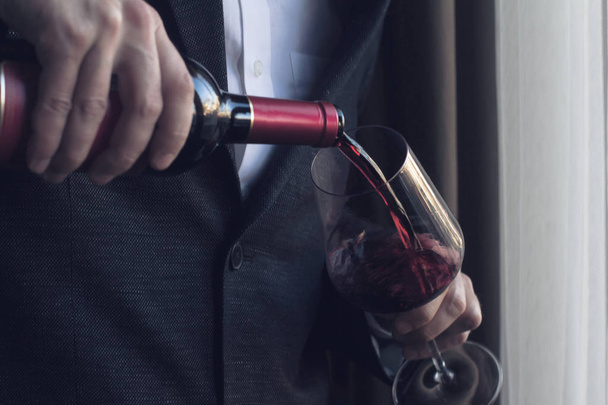 muž nalil do sklenice červené víno - Fotografie, Obrázek