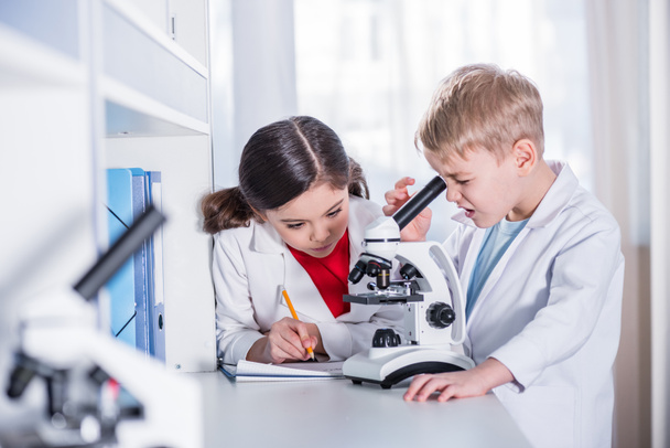 Niños usando microscopio
 - Foto, imagen