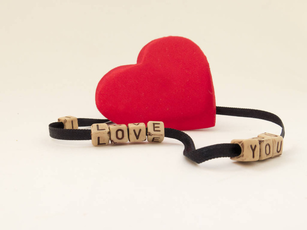 Red heart beads and the phrase I LOVE YOU - Foto, afbeelding