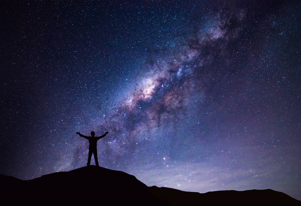 Milky Way τοπίο. Σιλουέτα της ευτυχισμένος άνθρωπος στέκεται στην κορυφή του βουνού με το νυχτερινό ουρανό και φωτεινό αστέρι στο φόντο.  - Φωτογραφία, εικόνα