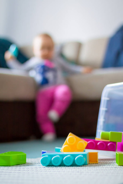 Little girl playing with plastic blocks. - Фото, зображення