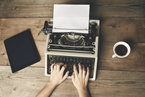 La mujer está escribiendo en una vieja máquina de escribir
. - Foto, Imagen