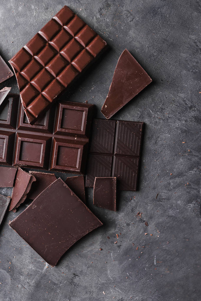 Шоколадные кусочки шоколада. Шоколадные кусочки. большая плитка шоколада на деревянном фоне. Шоколадные конфеты
.  - Фото, изображение