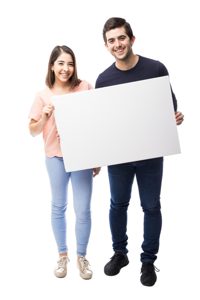 Hispanic couple holding sign - Фото, изображение