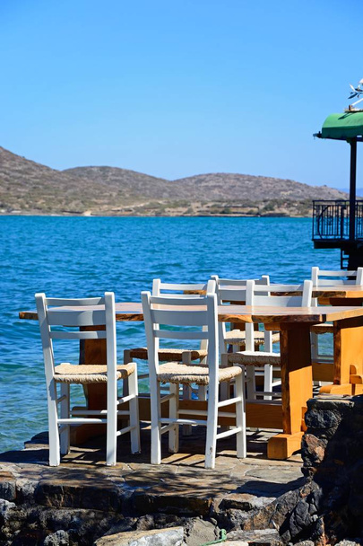 Bay, Elounda, Crete genelinde manzaralı sahildeki Restoran tablolar. - Fotoğraf, Görsel
