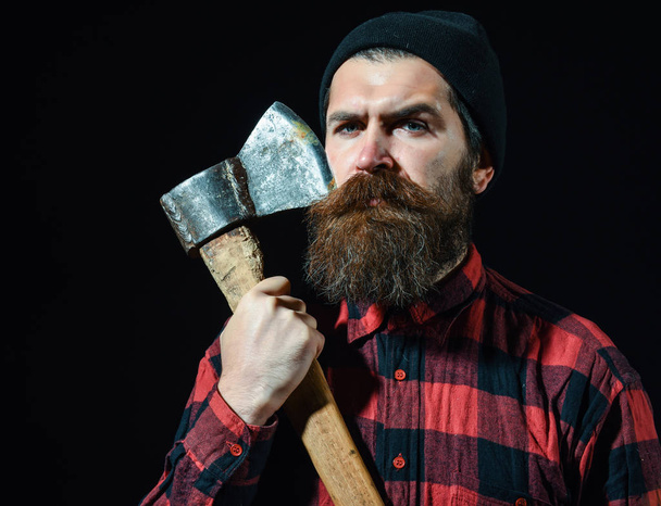 Handsome bearded man in hat holds axe on black background - Foto, immagini