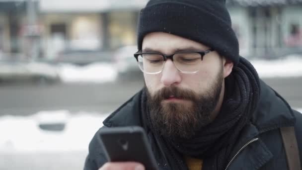 Bartträger tippt SMS am Telefon im Freien - Filmmaterial, Video