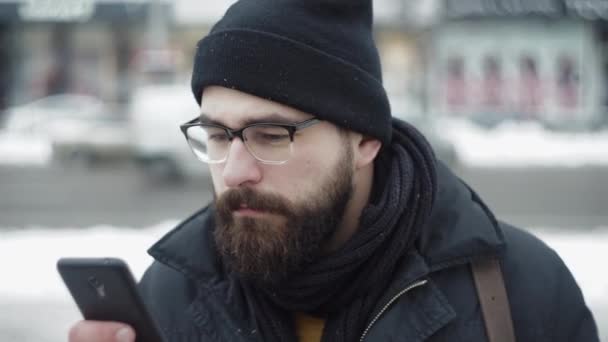 Πόλη άνθρωπος χρησιμοποιεί smartphone και πίνοντας τσάι στον δρόμο χειμώνα - Πλάνα, βίντεο