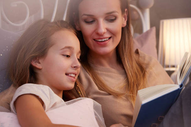 moeder aan dochter lezen - Foto, afbeelding