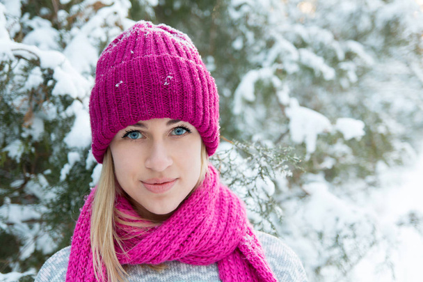 Closeup winter portrait of young girl in pink hat and scarf - Photo, Image