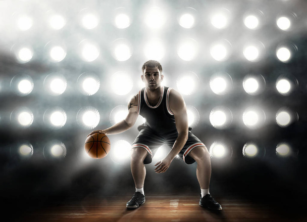 basketball player on floodlight background and parquet with ball - Zdjęcie, obraz