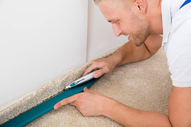 Man Cutting Carpet - Фото, зображення